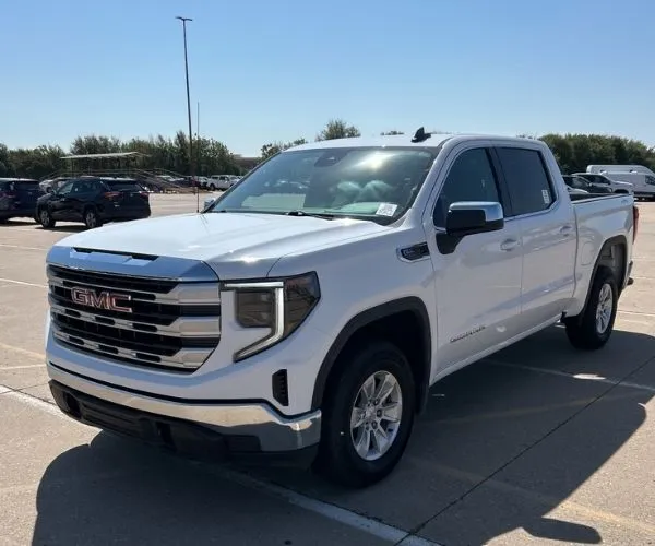 A white 2023 GMC Sierra 1500 pick up truck parked in a dealer lot