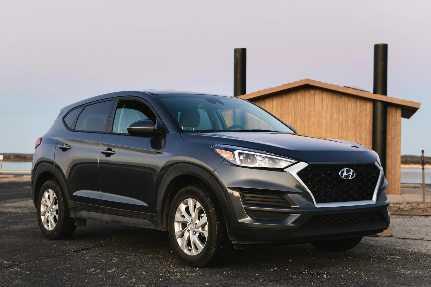 A black Hyundai parked in an empty lot