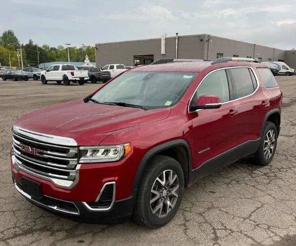 A red 2022 GMC Acadia in a dealership parking lot